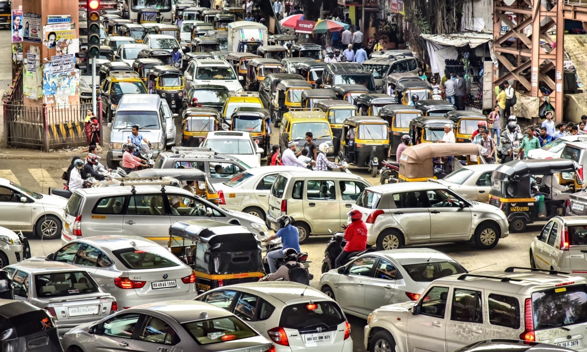 Heavy city traffic of cars, motorcycles, and three wheeler taxis